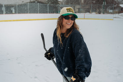 Outland Club Co. Dallas City Ice Classic Snapback Hat close portrait, green brim Texas hockey snapback worn with hockey equipment at outdoor rink